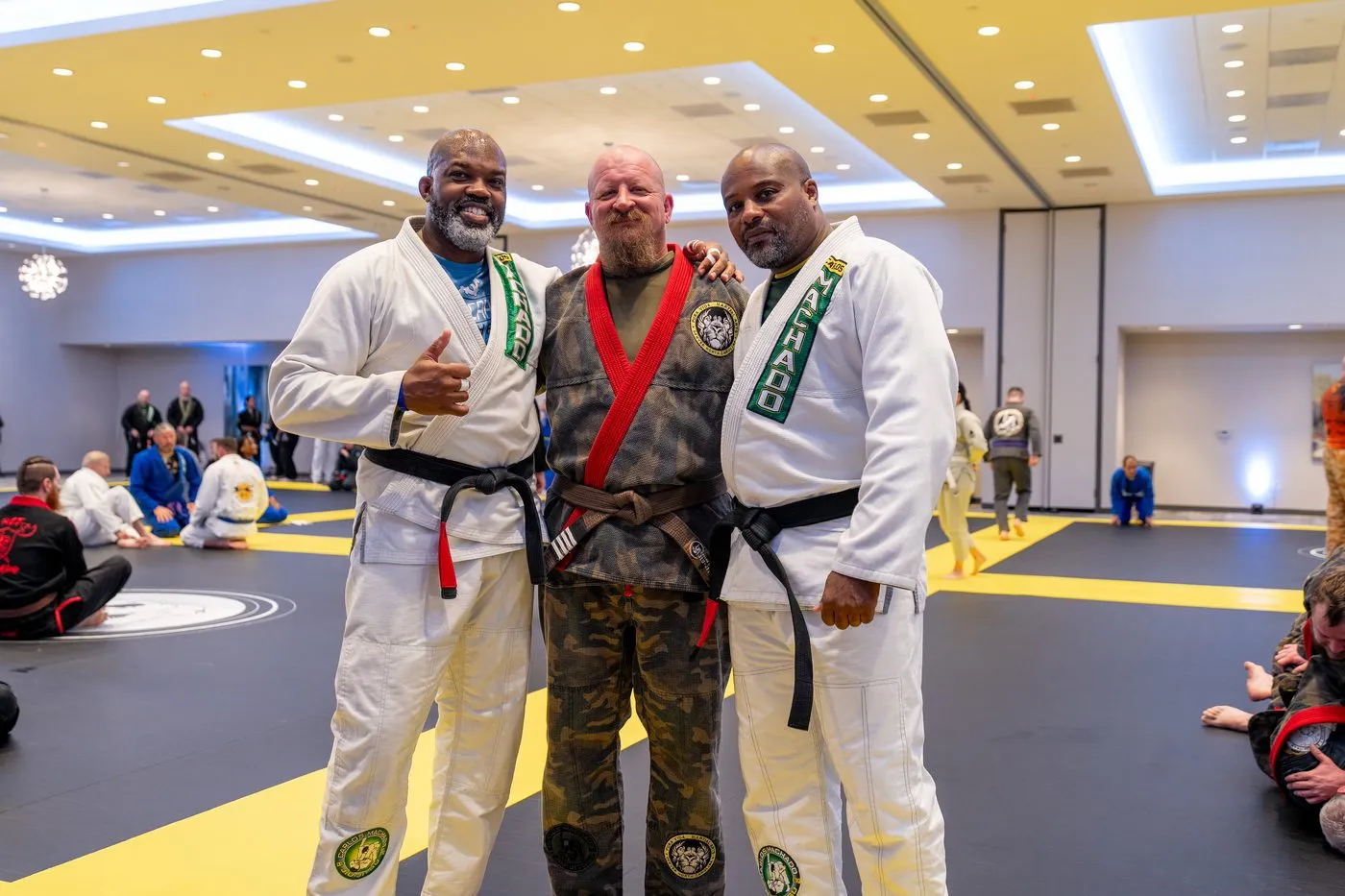 Three black belts in Machado gis standing together on the mat